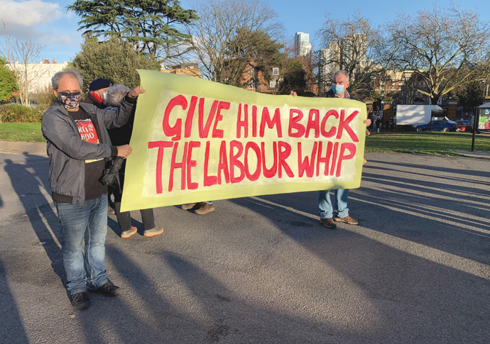 Behind the masks, the need for debate Corbyn protest with banner