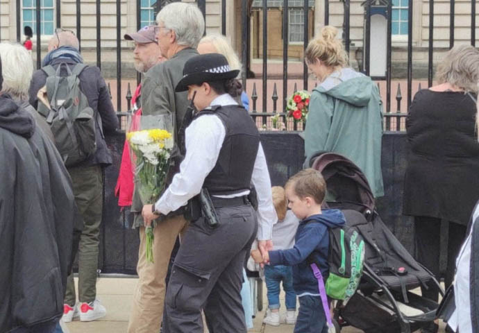 Police with boy in Queen tribute queue