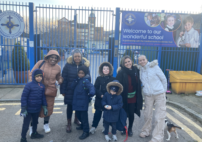 Parents outside the school this week with its new banner describing its partnership with the Cardinal Hume Academies